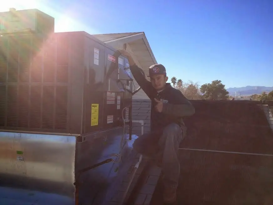 HVAC technician performing Heat Pump Repair on a rooftop unit in Sebring